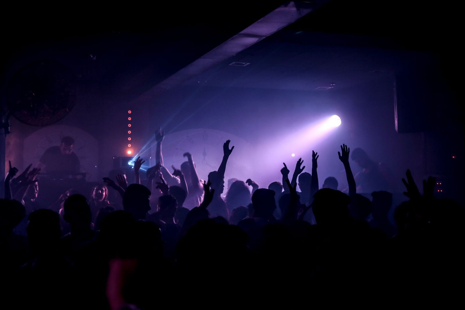 Crowd dancing under spotlights at a late-night party, typical of theme cruises for adults