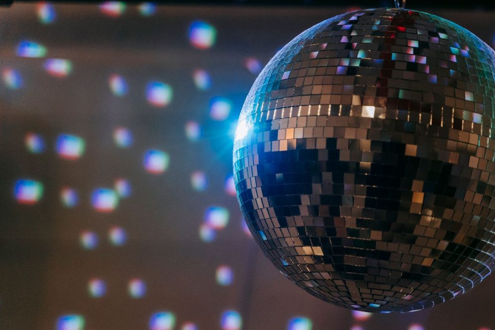 Disco ball reflecting colored lights in a dim room