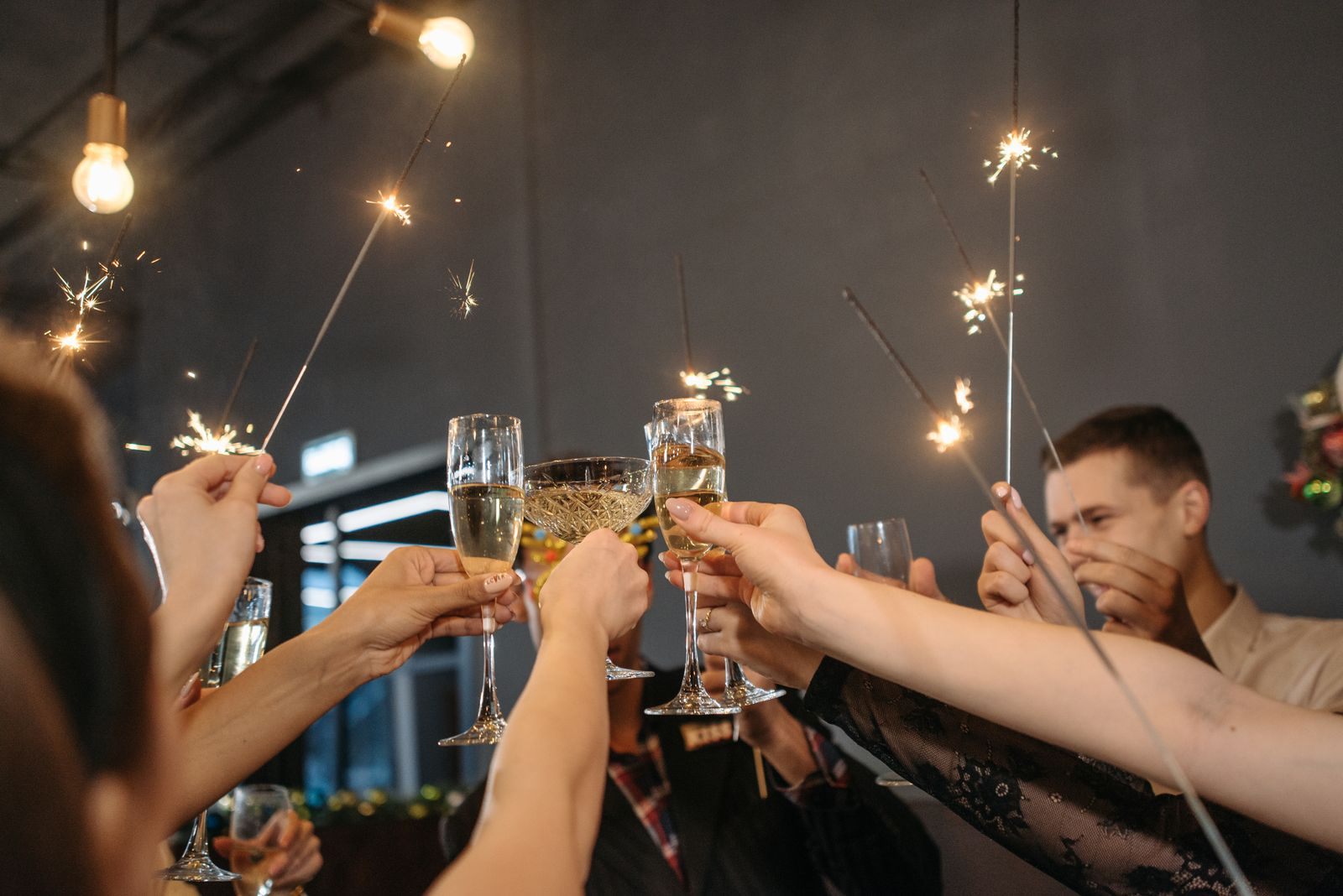 Group of adults celebrating with sparklers and champagne