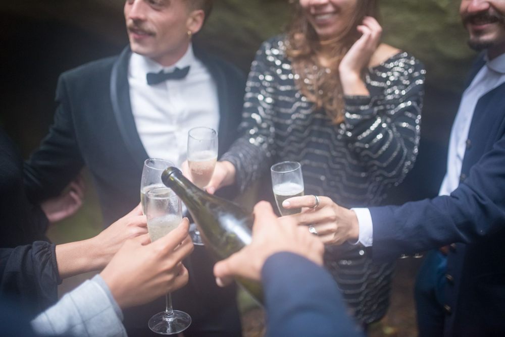 Friends raising champagne glasses together at an outdoor party