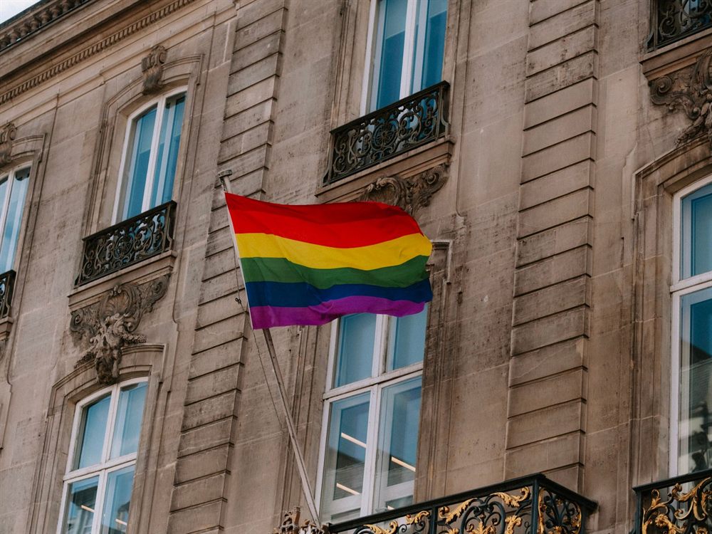 Rainbow pride flag hanging from a historic building